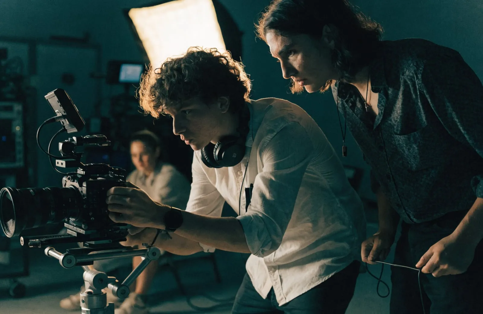 Film crew operating a cinema camera on a lit set